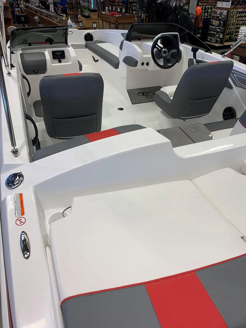 Slide: The Image of 2024 Tahoe T21 boat interior with gray and red seating, steering wheel, and dashboard. - 26