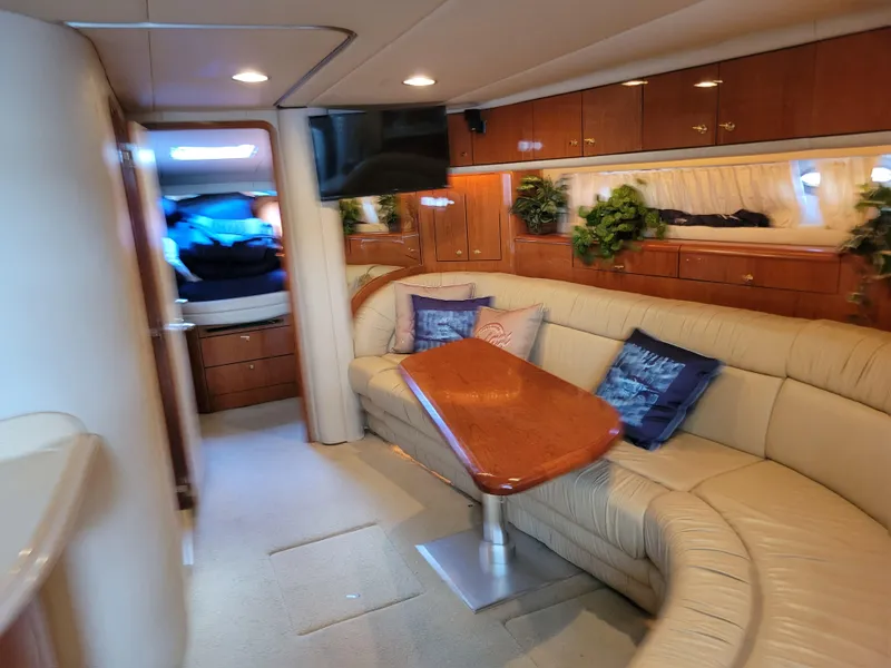 Slide: The Image of Interior of 2000 Sea Ray 540 Sundancer yacht with plush seating and wooden table. - 40