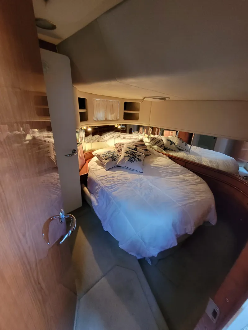 Slide: The Image of 2000 Sea Ray 540 Sundancer bedroom with cozy bed and mirrored walls. - 30