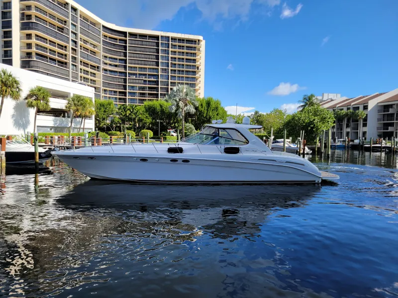Slide: The Image of 2000 Sea Ray 540 Sundancer yacht docked in a marina with modern buildings. - 1