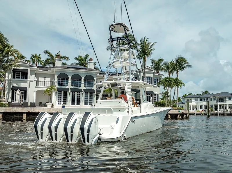 Slide: The Image of 2021 SeaVee 450z boat with quad engines cruising near luxury waterfront homes. - 4