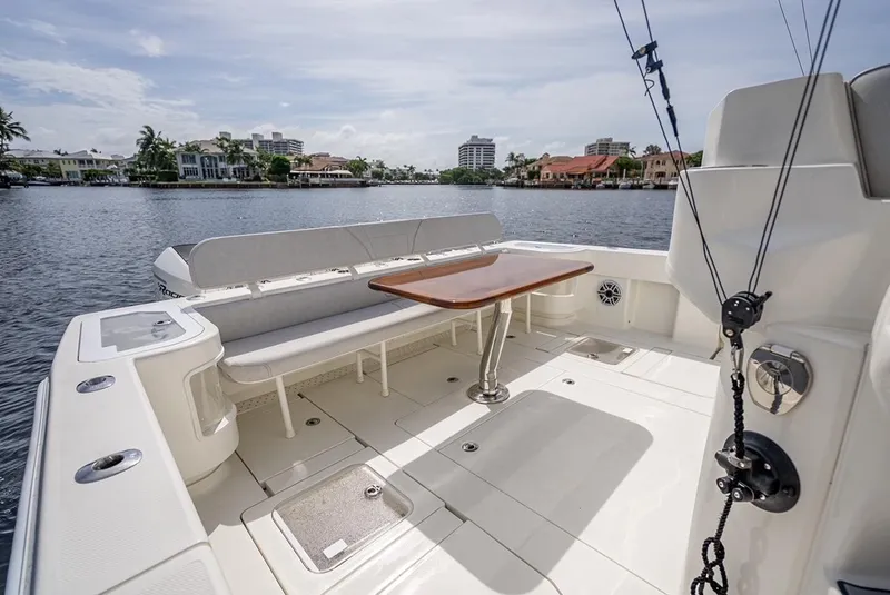 Slide: The Image of 2021 SeaVee 450z boat with spacious deck and seating area on a calm waterfront. - 5