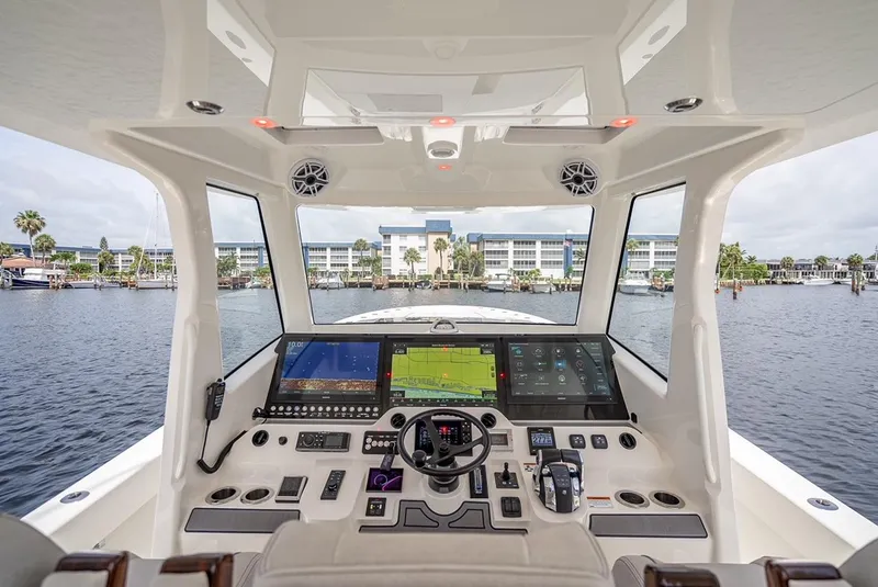 Slide: The Image of 2021 SeaVee 450z boat helm with advanced navigation systems and waterfront view. - 8