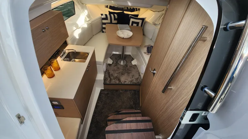 Slide: The Image of 2024 Jeanneau Leader 9.0 WA S2 cabin interior with kitchenette and seating area. - 26