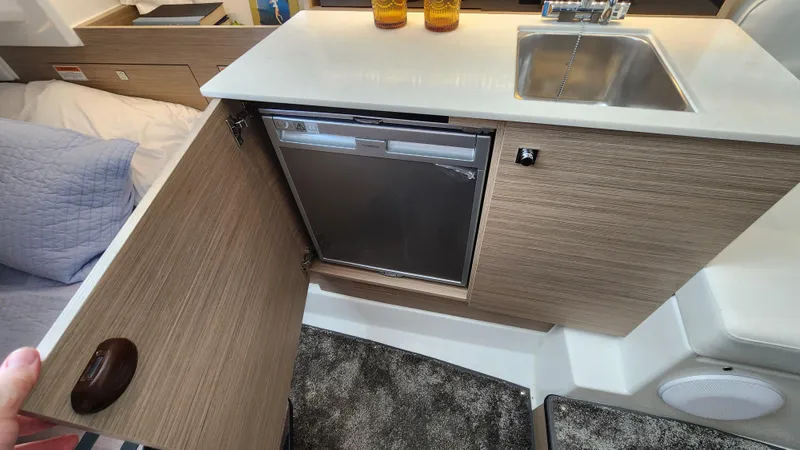 Slide: The Image of Compact kitchen area in the 2024 Jeanneau Leader 9.0 WA S2 boat with sink and mini-fridge. - 28