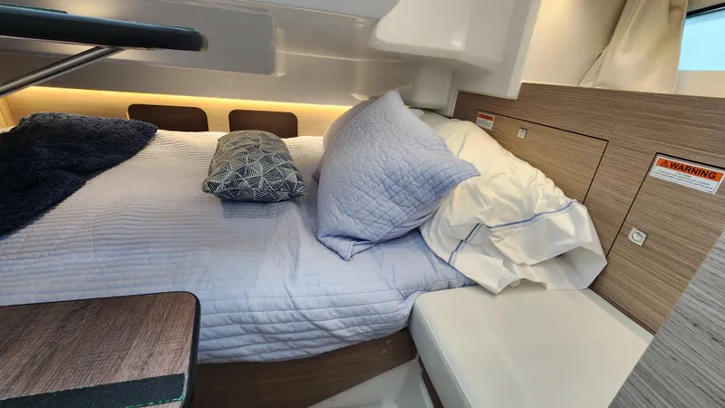 Slide: The Image of Cozy cabin interior of 2024 Jeanneau Leader 9.0 WA S2 with bed and pillows. - 31