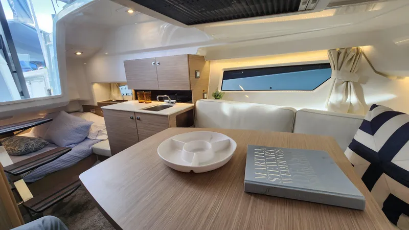 Slide: The Image of Interior of 2024 Jeanneau Leader 9.0 WA S2 boat with modern kitchen and cozy seating area. - 36