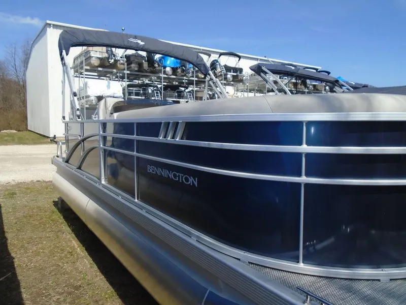 Slide: The Image of 2024 Bennington 21 SXL pontoon boat with blue exterior, docked outdoors. - 15