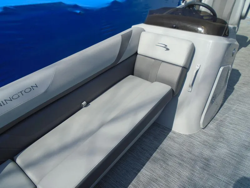 Slide: The Image of 2024 Bennington 21 SXL boat interior with gray seating and steering console. - 22