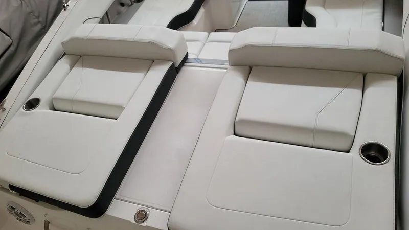 Slide: The Image of 2024 Regal LS2 boat interior with white cushioned seating and cup holders. - 6