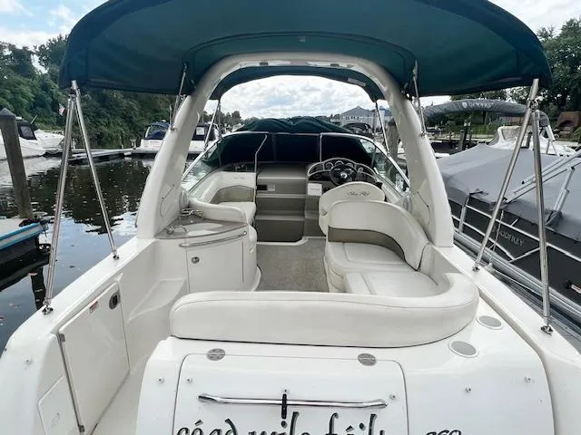 Slide: The Image of 2005 Sea Ray 260 Sundancer boat with white seating and green canopy docked at marina. - 5