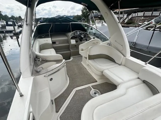 Slide: The Image of 2005 Sea Ray 260 Sundancer boat interior with white seating and helm. - 6
