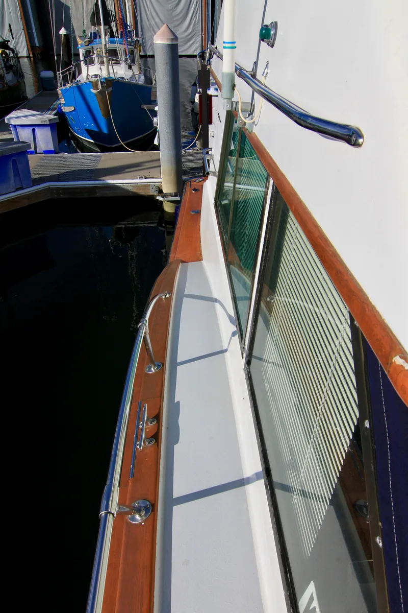 Slide: The Image of Side deck view of a 1977 Hatteras 37 Convertible yacht docked at a marina. - 13