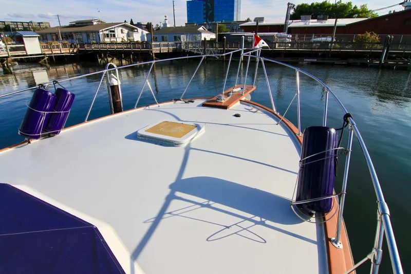 Slide: The Image of Bow view of 1977 Hatteras 37 Convertible yacht docked at marina. - 14