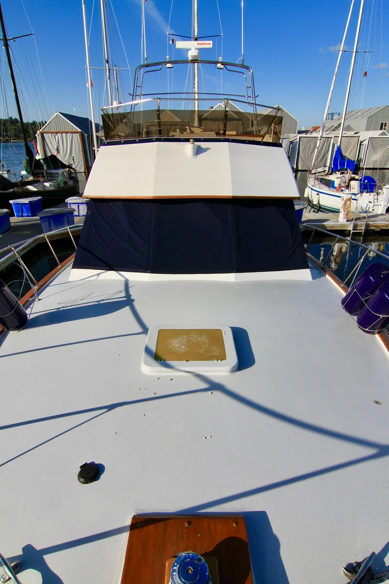 Slide: The Image of 1977 Hatteras 37 Convertible yacht docked at a marina. - 16