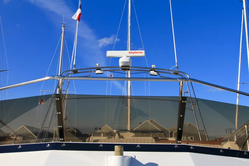 Slide: The Image of 1977 Hatteras 37 Convertible yacht with Raytheon radar, docked under clear blue sky. - 19