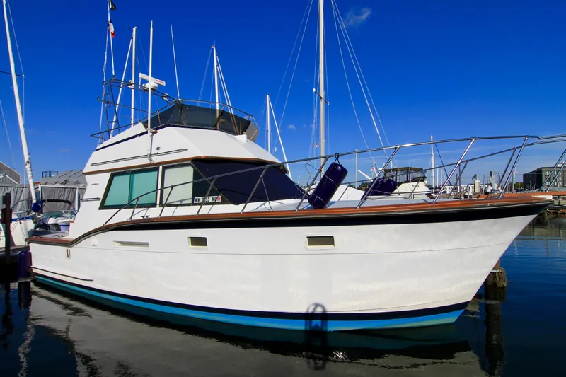 Slide: The Image of 1977 Hatteras 37 Convertible yacht docked at a marina on a sunny day. - 3
