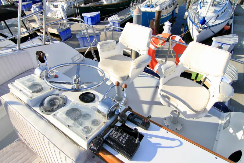 Slide: The Image of 1977 Hatteras 37 Convertible yacht helm with dual captain chairs at marina. - 31