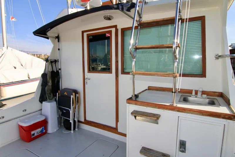 Slide: The Image of 1977 Hatteras 37 Convertible boat deck with door, ladder, and sink. - 35