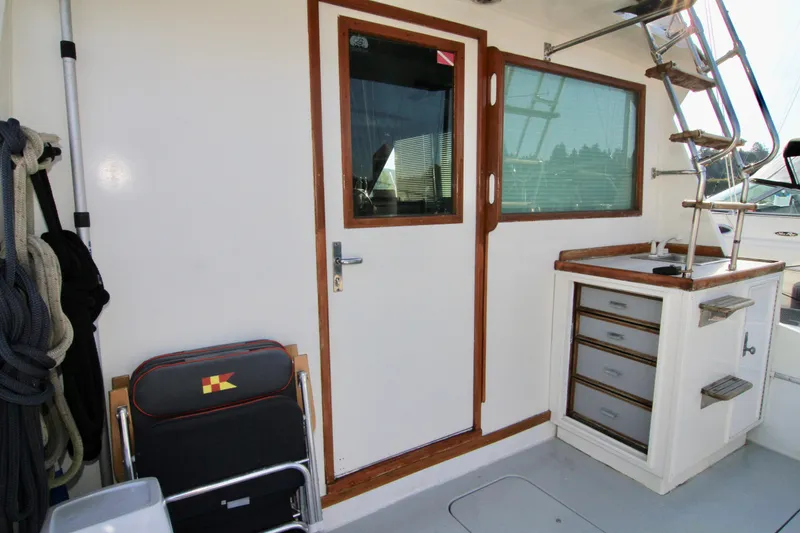 Slide: The Image of 1977 Hatteras 37 Convertible boat interior with door, window, and storage drawers. - 36