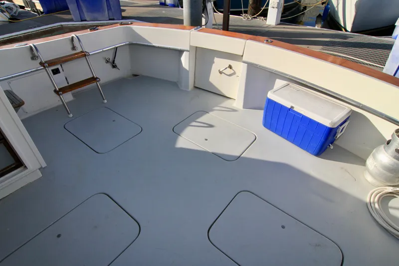 Slide: The Image of 1977 Hatteras 37 Convertible boat deck with storage compartments and a blue cooler. - 37