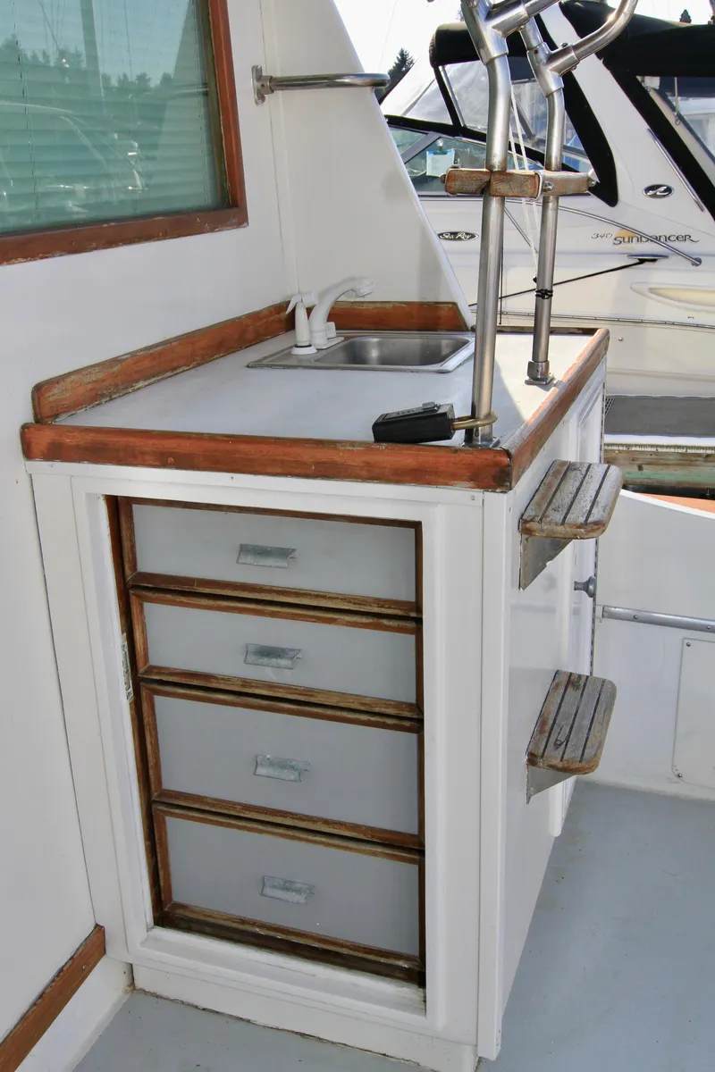 Slide: The Image of 1977 Hatteras 37 Convertible boat interior with sink and storage drawers. - 38