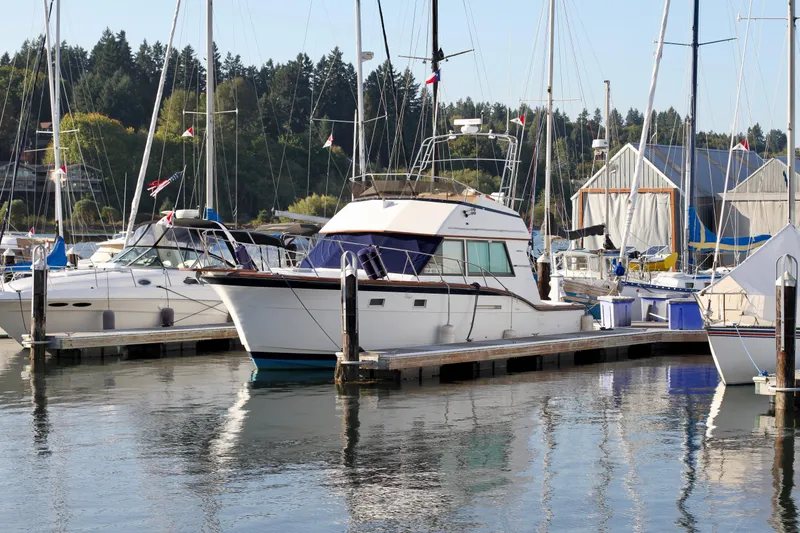 Slide: The Image of 1977 Hatteras 37 Convertible yacht docked at a marina with other boats. - 42