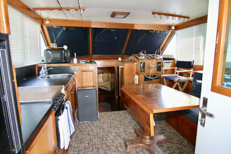 Slide: The Image of 1977 Hatteras 37 Convertible yacht interior with kitchen, dining area, and helm station. - 45