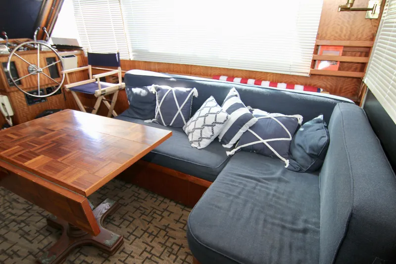 Slide: The Image of Interior of 1977 Hatteras 37 Convertible with blue sofa, wooden table, and nautical decor. - 46