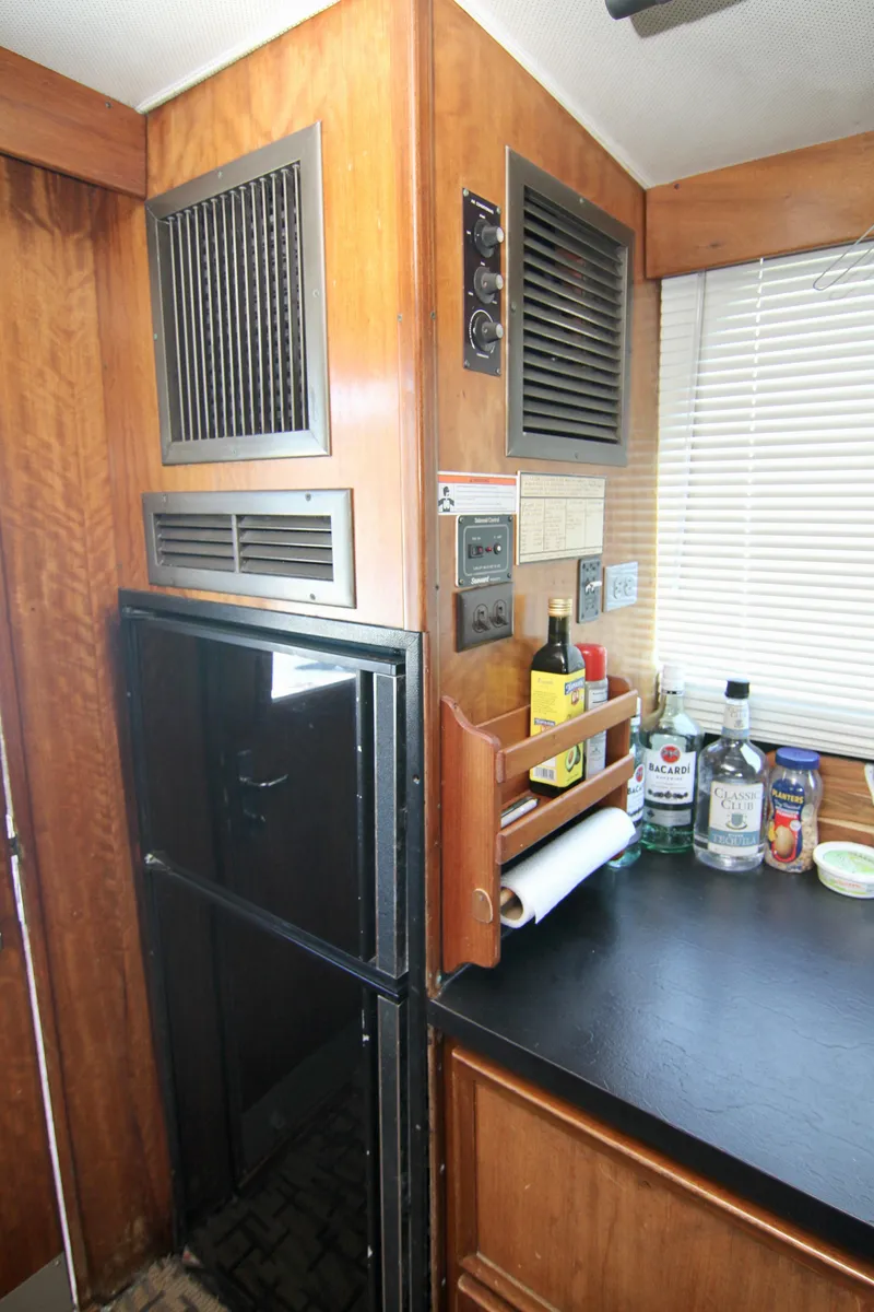 Slide: The Image of 1977 Hatteras 37 Convertible kitchen with wooden cabinetry, refrigerator, and countertop. - 49