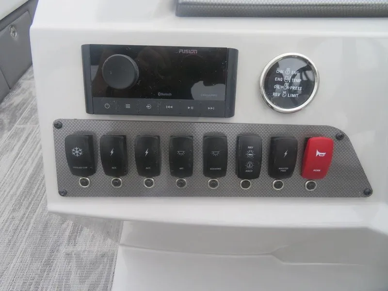 Slide: The Image of Control panel of 2024 Crest Classic LX 240 SLRC boat with switches and a Fusion stereo. - 6