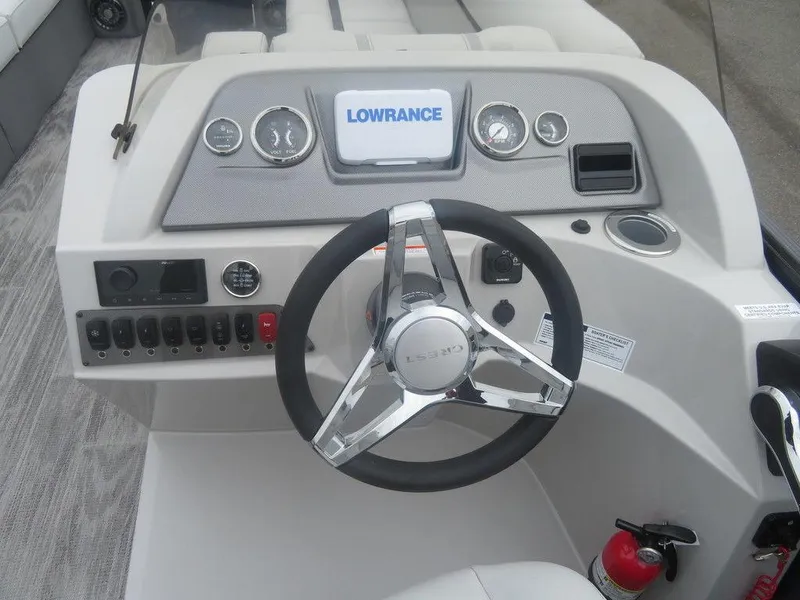 Slide: The Image of 2024 Crest Classic LX 240 SLRC boat dashboard with Lowrance display and steering wheel. - 7