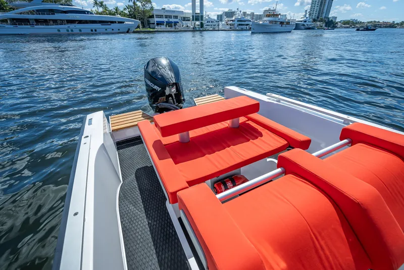 Slide: The Image of 2021 Goldfish 23 Tender boat with red seating, docked in a marina. - 12