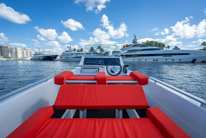 Slide: The Image of Goldfish 23 Tender 2021 boat with red seating, docked near luxury yachts. - 14