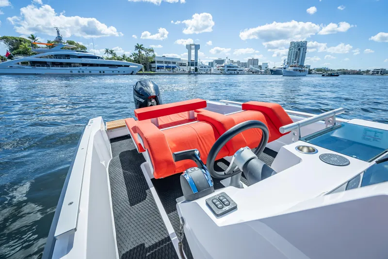 Slide: The Image of 2021 Goldfish 23 Tender boat with red seats on a sunny day in a marina. - 15
