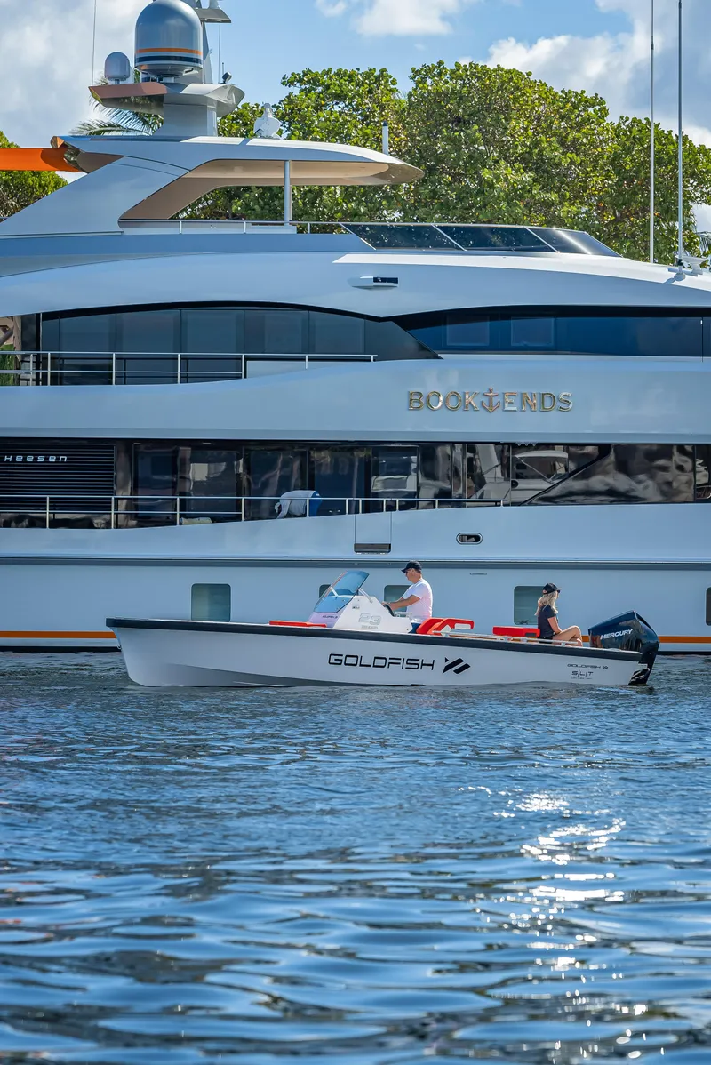 Slide: The Image of 2021 Goldfish 23 Tender boat cruising near a large yacht on a sunny day. - 17