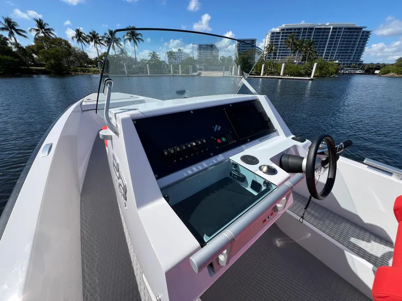 Slide: The Image of 2021 Goldfish 23 Tender boat dashboard with steering wheel, on a sunny waterfront. - 19
