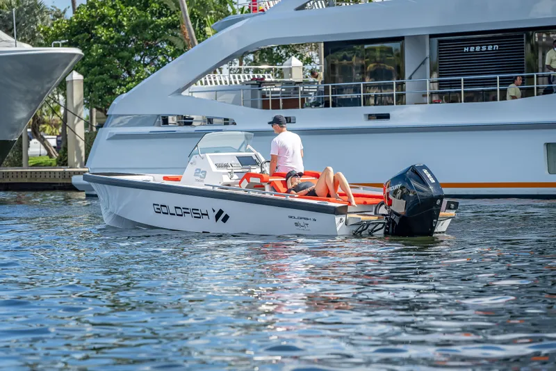 Slide: The Image of 2021 Goldfish 23 Tender boat on water near a large yacht. - 7