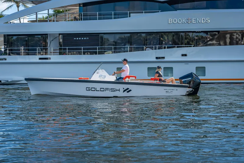 Slide: The Image of 2021 Goldfish 23 Tender boat cruising on water with two passengers. - 8