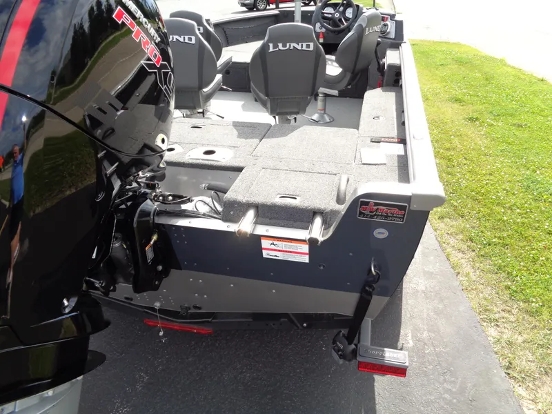 Slide: The Image of 2024 Lund 1875 Impact XS SS boat, rear view, featuring seating and motor. - 10