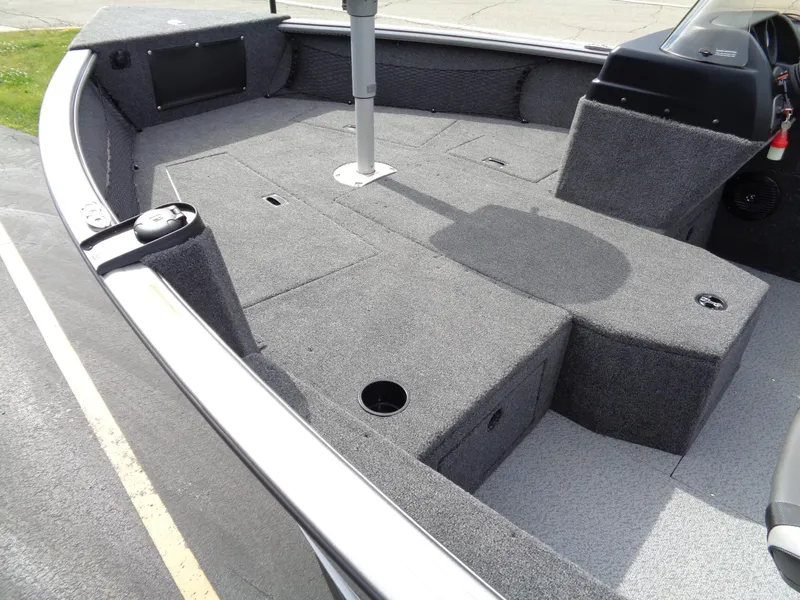 Slide: The Image of 2024 Lund 1875 Impact XS SS boat interior with carpeted deck and seating. - 6