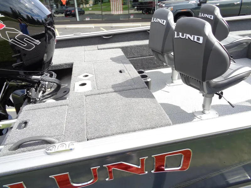 Slide: The Image of 2024 Lund 1875 Impact XS SS boat interior with seating and motor. - 9