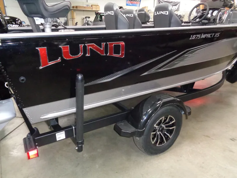 Slide: The Image of 2024 Lund 1875 Impact XS SS boat on trailer, side view. - 2