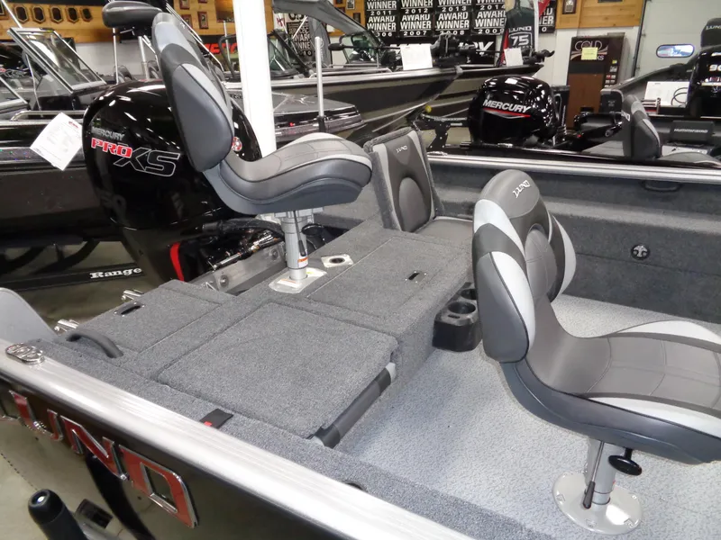 Slide: The Image of 2024 Lund 1875 Impact XS SS boat interior with seating and steering wheel. - 7