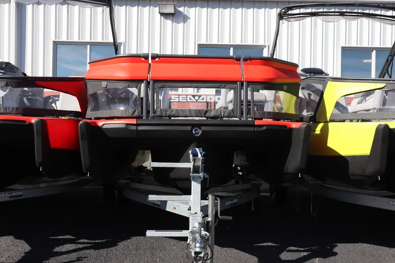 The Image of 2024 Sea-Doo Switch 16 pontoon boat on trailer, parked outside a building. - 0