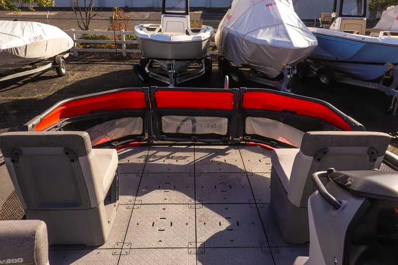 Slide: The Image of 2024 Sea-Doo Switch 16 interior with seating, docked among covered boats. - 12