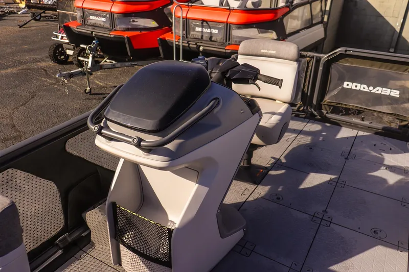 Slide: The Image of 2024 Sea-Doo Switch 16 interior with steering console and seating, parked outdoors. - 13