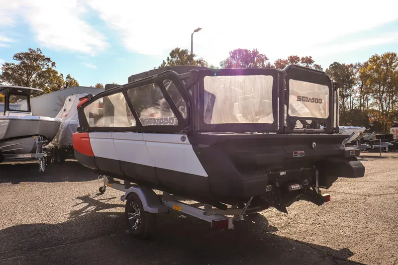 Slide: The Image of 2024 Sea-Doo Switch 16 pontoon boat on trailer, parked outdoors in sunlight. - 4