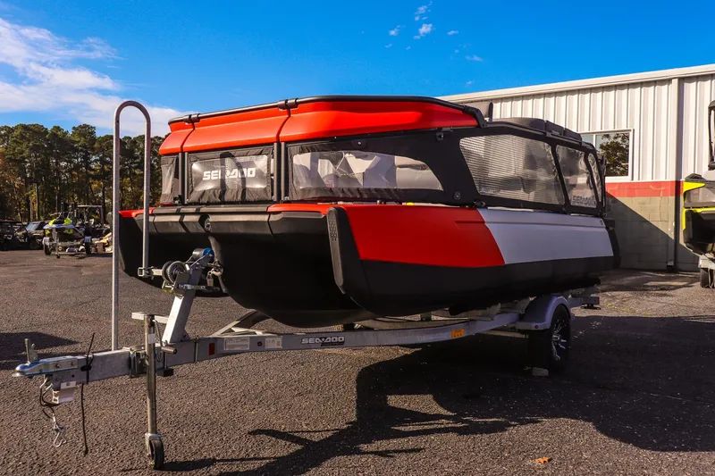 Slide: The Image of 2024 Sea-Doo Switch 16 on trailer, vibrant red and black design, parked outdoors. - 6