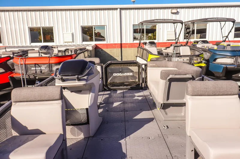Slide: The Image of 2024 Sea-Doo Switch 16 pontoon boat interior with seating and helm, displayed outdoors. - 8